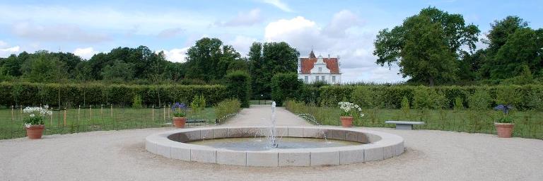 Baroque garden with fountain in the foreground and Søholt Manor in the background